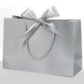 Bolsas de Papel Plata LUJO con Lazo Plateado , Asa Rizada Gruesa y Papel Reforzado, Bolsas de Regalo Elegante para Tiendas y Packaging, Pack de 6 Unidades, Varios Tamaños Disponibles - BOLSASYMASBCN.COM